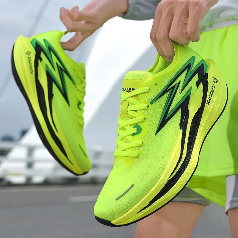 Bright green running shoes with black accents held by a person on a blurred background