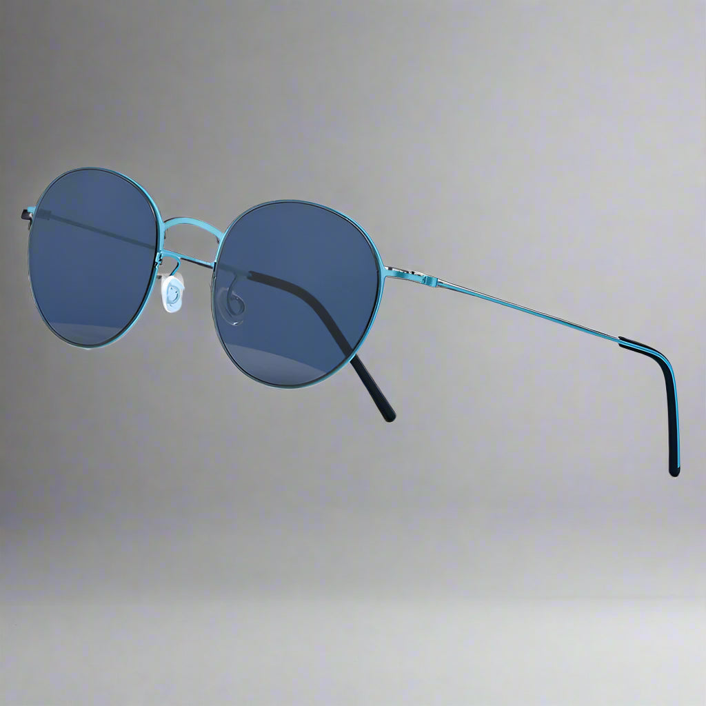 Sunglasses with blue lenses and green frames on a white stand against a light blue background, featuring the TAG Hezekiah Eyewear logo.
