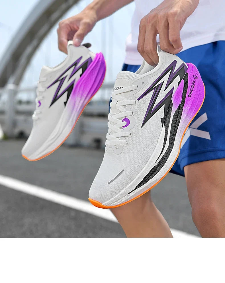 Person holding white running shoes with purple and black accents on a blurred street background